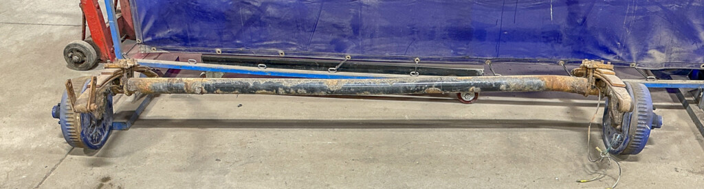 Trailer axle with a major kink on the side that needs replacing.