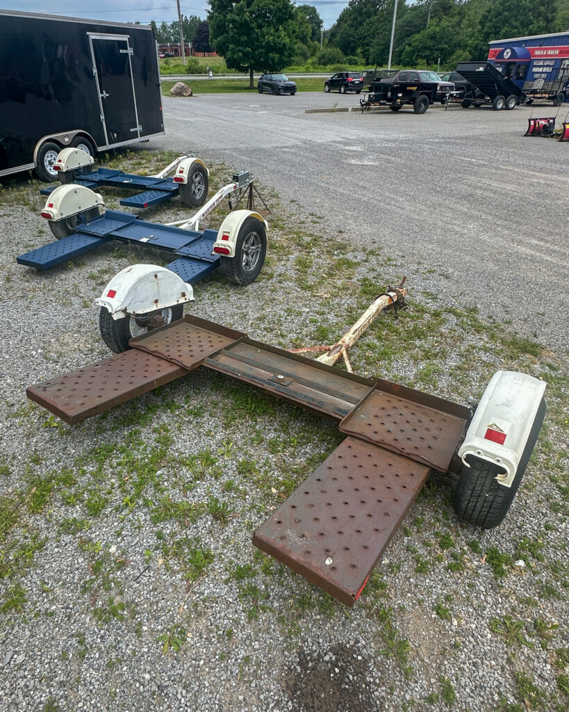 Full image of a pre-owned blue and white tow dolly parked on pavement, ready for pickup at GWFab’s Elma, NY location.