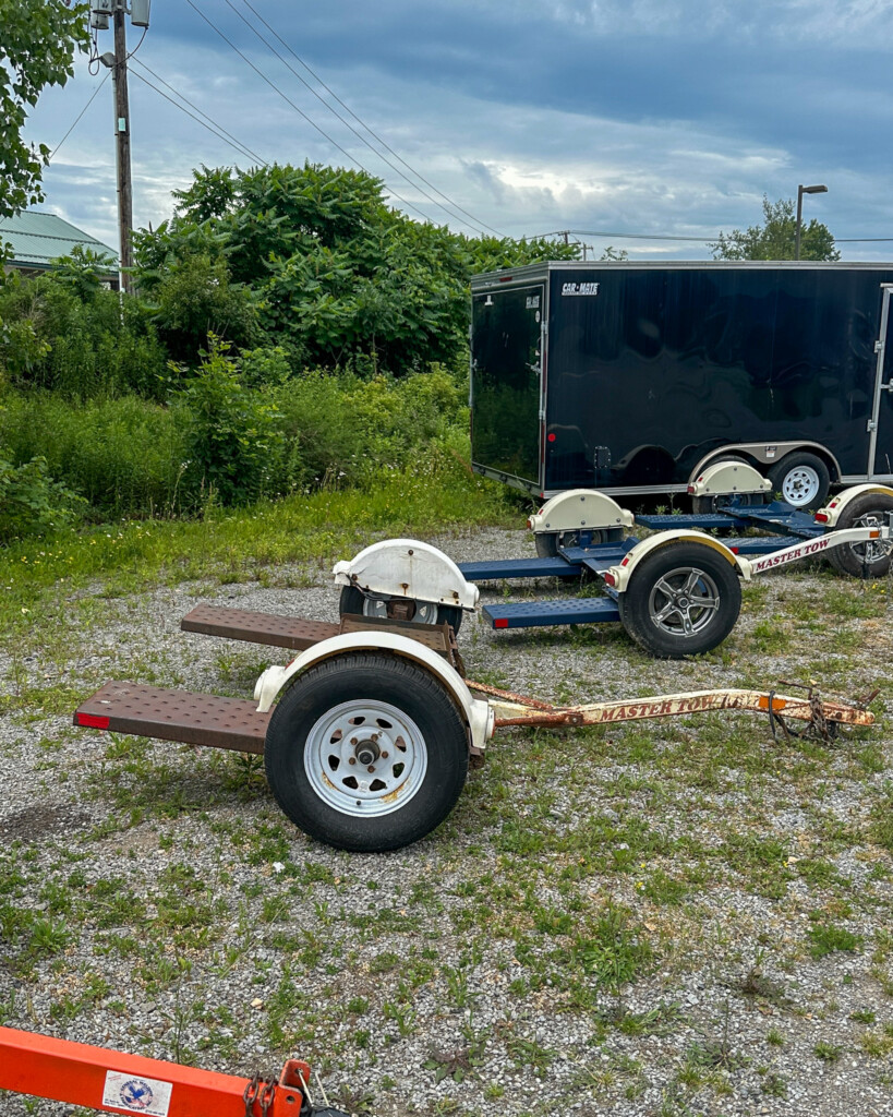 Side view of a used Master Tow tow dolly with sturdy wheel straps and fenders, available for sale at General Welding & Fabricating.